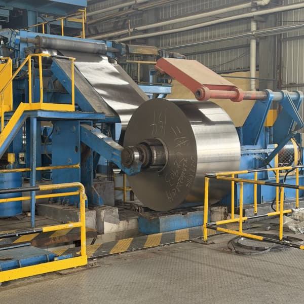 Precision digital gauge measuring thickness of black annealed steel coil.