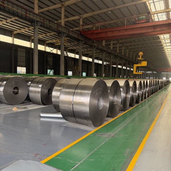 Factory overhead crane lifting steel cold rolled coil for container packing.